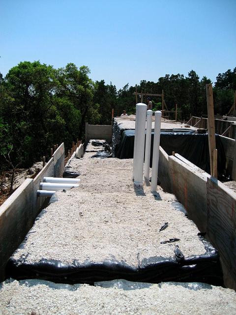 PipesInForm.jpg - Rainwater collection pipes. These will be embedded in concrete foundation and will connect vortex filters to  pipes leading to storage tanks down the hill at left. April 5, 2007.