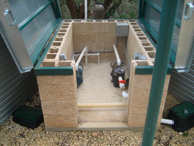 PumpHouse8.JPG - Pump house with roof panels and front hatch in open position. The pump on the left is for water supply to the house; the other supplies the external circulating filter. January 19, 2010.