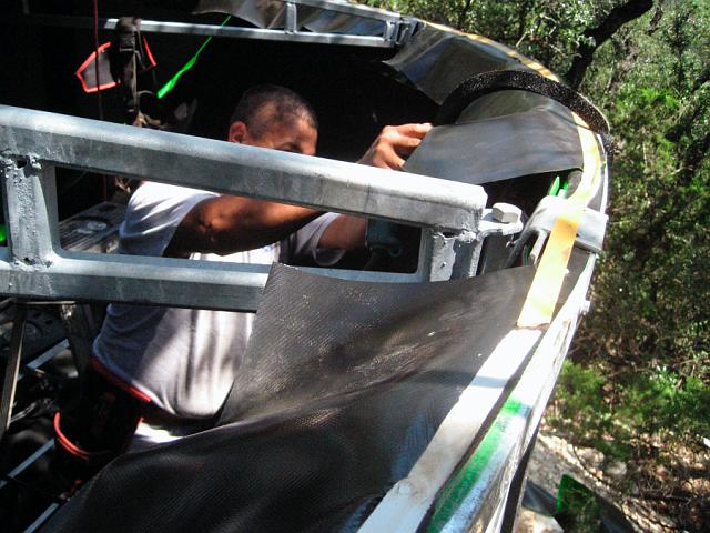 Tank10.JPG - Bolting top edge of liner to eave.  Note (1)  "Prestite" foam seal that will be installed between sill and roof panels, and (2) strips that divert condensation from roof back into tank liner. September 25, 2007.